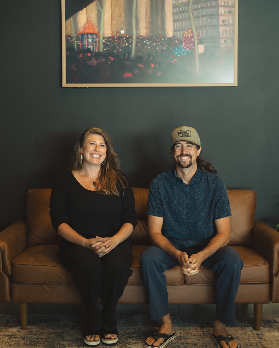Dr. Dan Martin and Dr. Sarah Ruszel on the leather couch at Radius Chiropractic