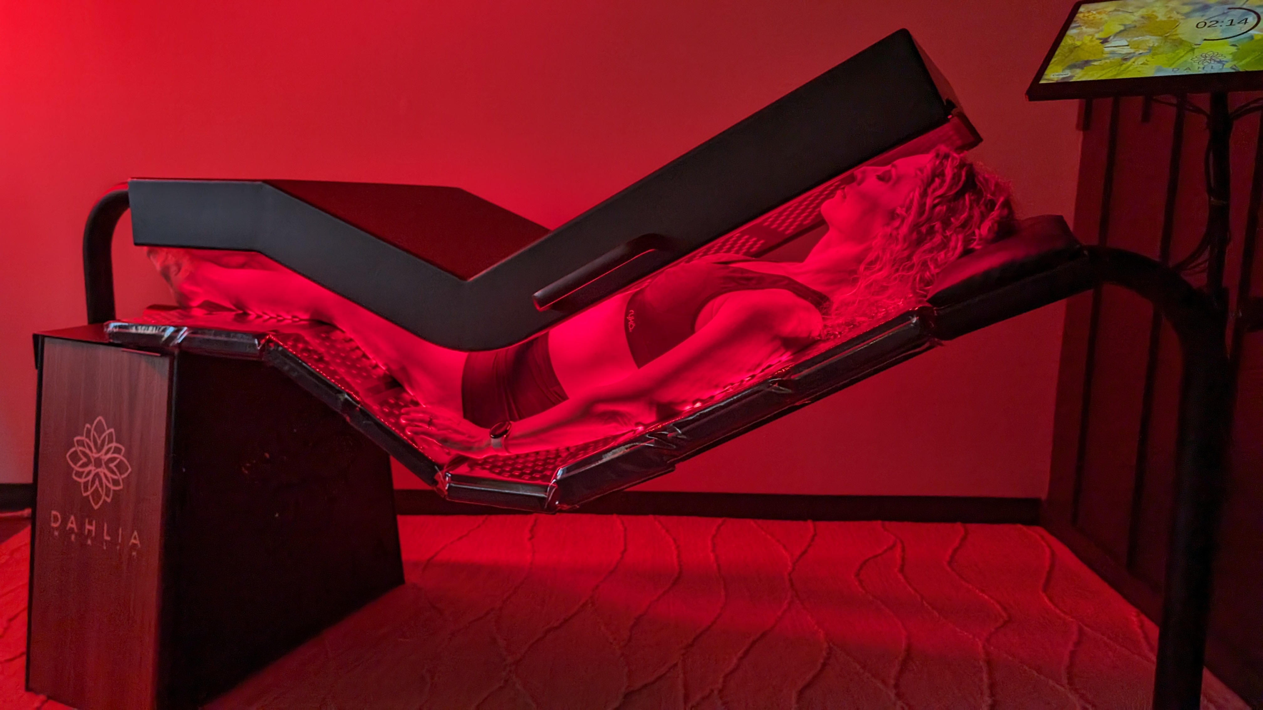 A guest resting on the Dahlia Pinnacle red light bed at Radius Chiropractic.
