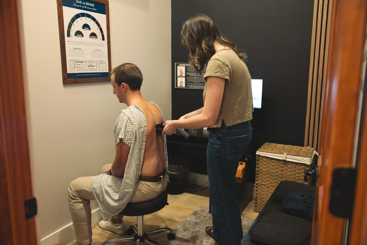 A neuroTHERMAL scan in progress: the scanner rolling up a seated patient's spine
