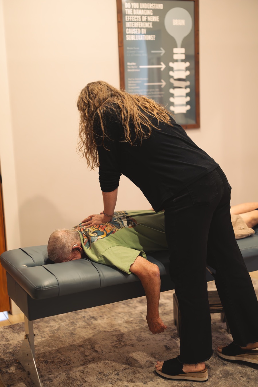 Dr. Sarah adjusting a patient's mid-back on the table