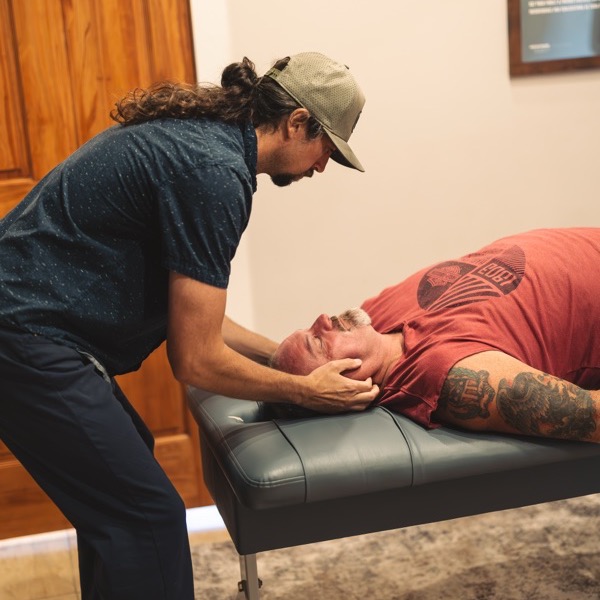 A doctor gently cradling a patient's neck during an adjustment