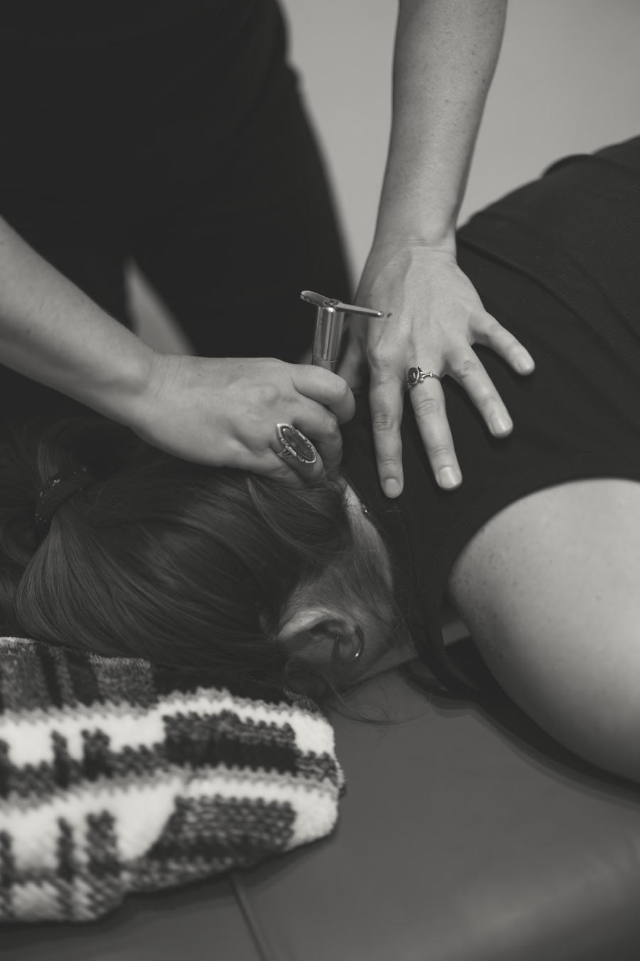 A close-up of the Integrator instrument during a prenatal adjustment, in black and white
