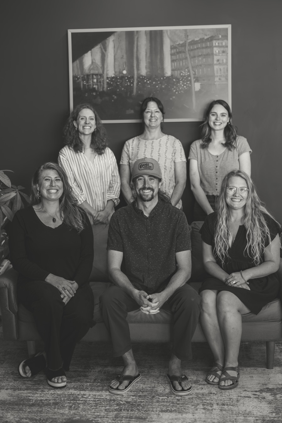 The whole Radius Chiropractic team together on the lobby couch, in black and white