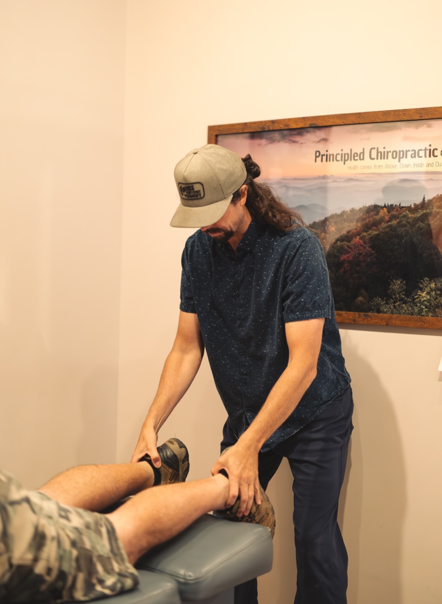 Dr. Dan checking a patient's leg length on the adjusting table