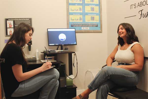 A doctor taking notes during a one-on-one health consultation with a patient